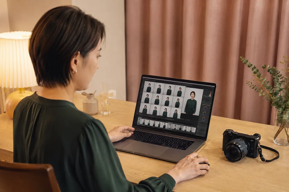 撮影したポートレートを投稿用に編集する成人女性。AI生成の作業環境イメージで、実際の出演者・サービス画面ではありません。
