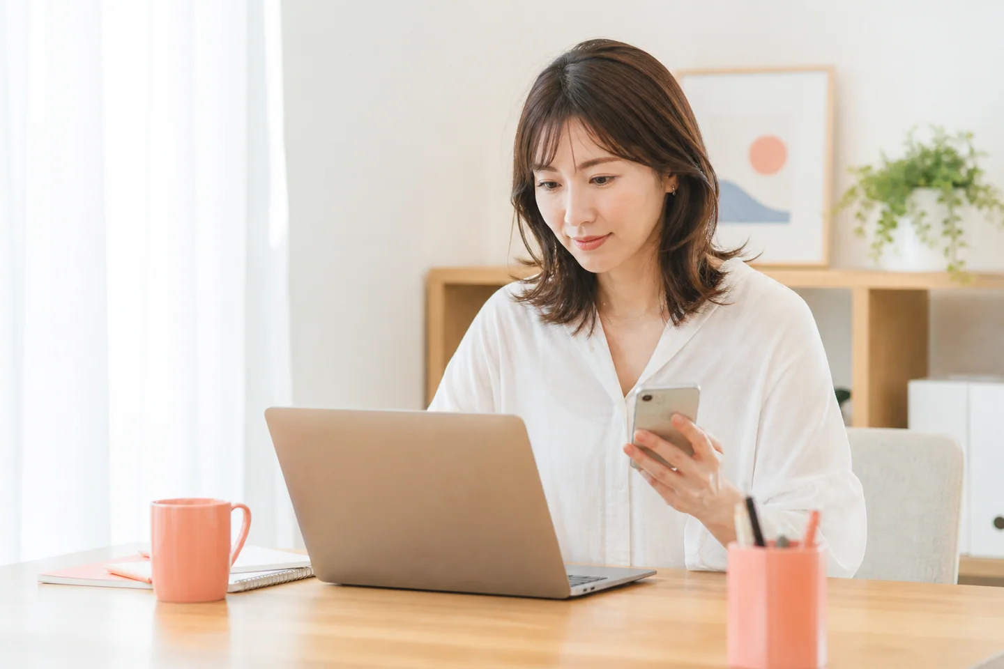 自宅のデスクで働き方について調べる女性