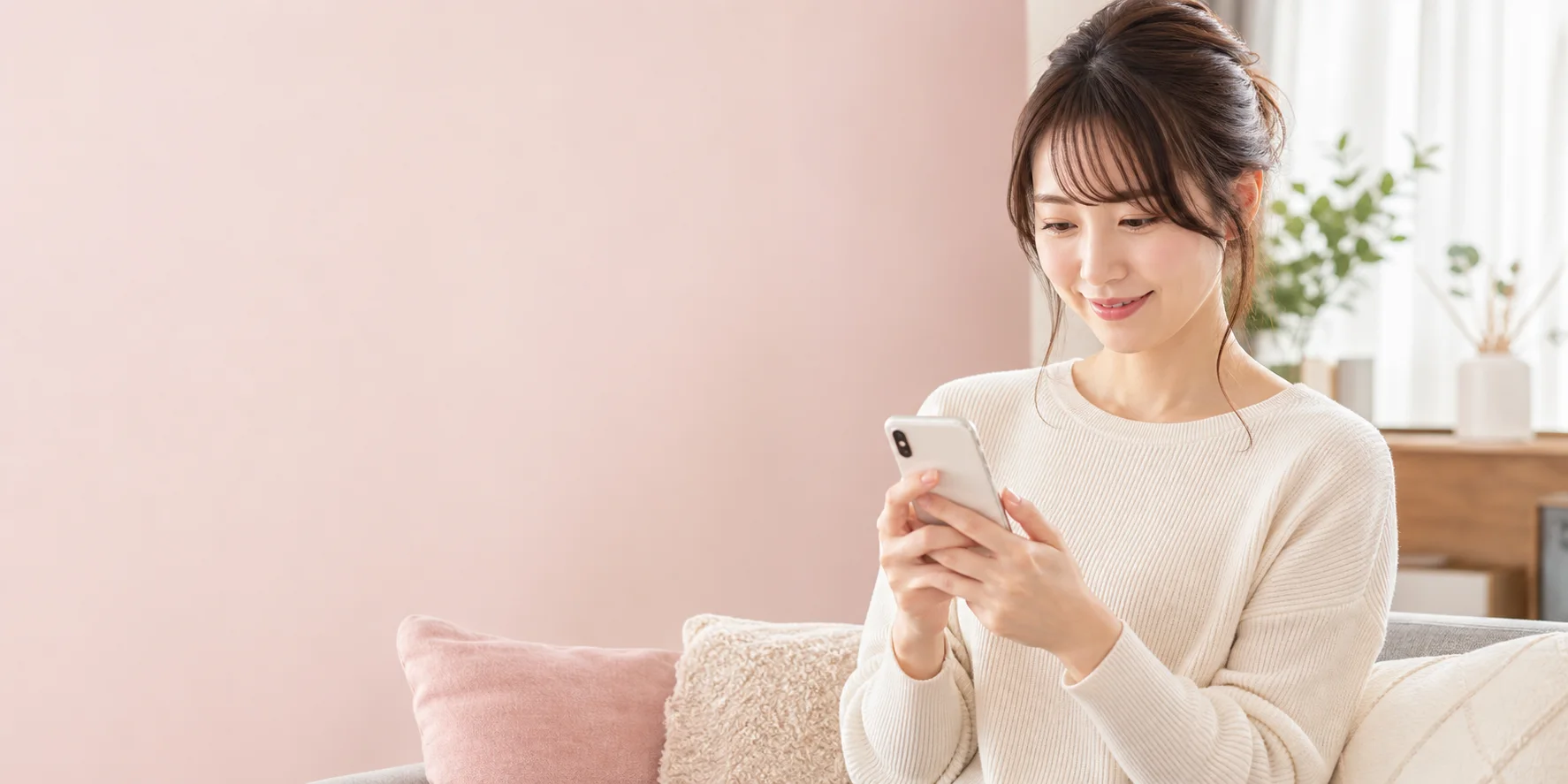 明るい部屋でスマートフォンを見ながら働き方を調べる女性