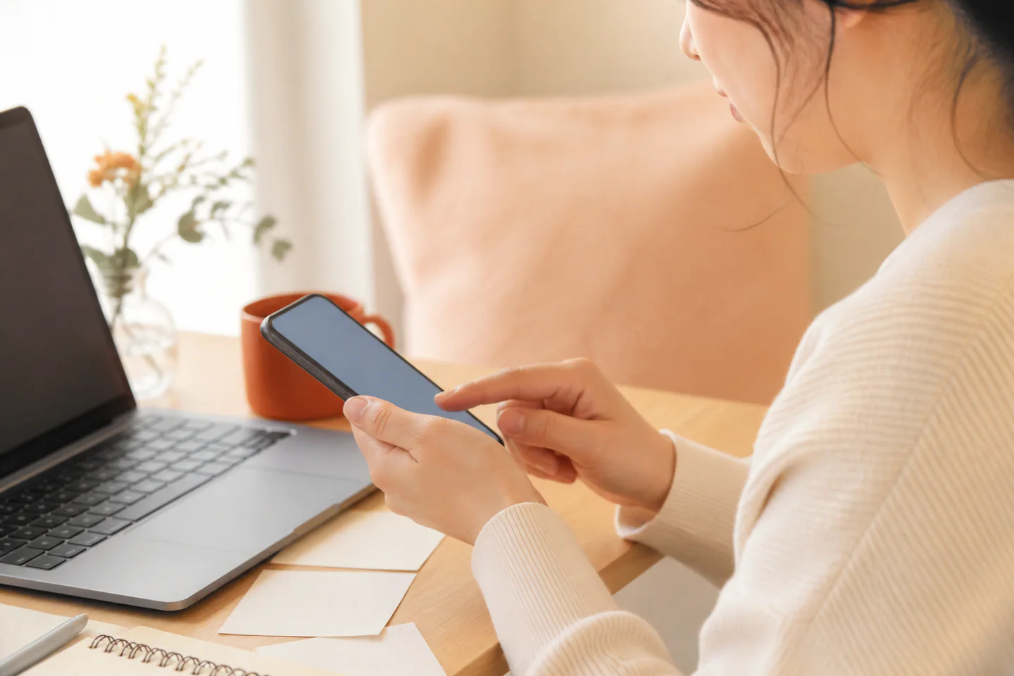 スマートフォンで文章やコンテンツ投稿を準備する女性の編集イメージ